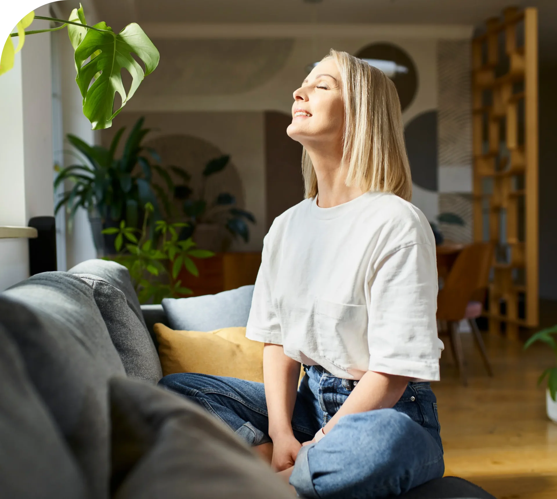 Woman enjoying sunlight on a couch.